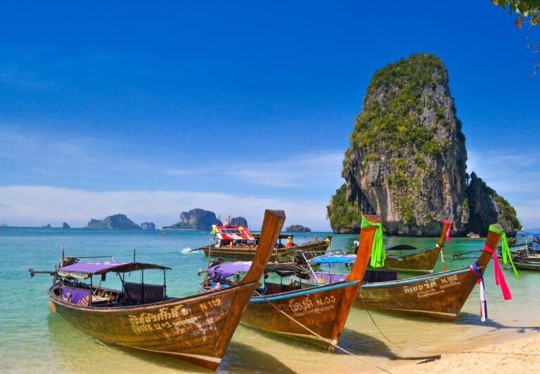 barcos en la orilla de una playa de tailandia, destino a donde viajar en febrero