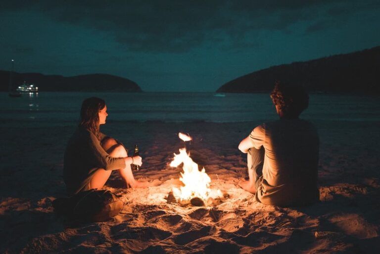 dos personas delante de una hoguera, mejores agencias de viaje para singles