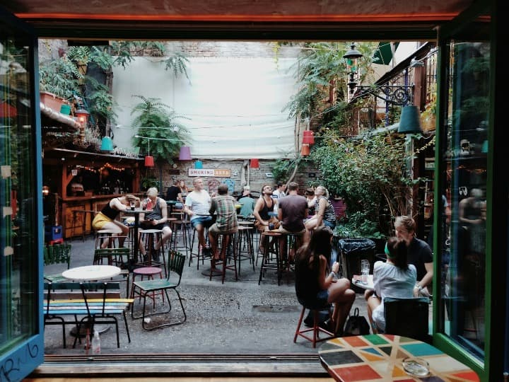 jardin del szimpla bar, uno de los ruin pubs de budapest, gente tomando algo