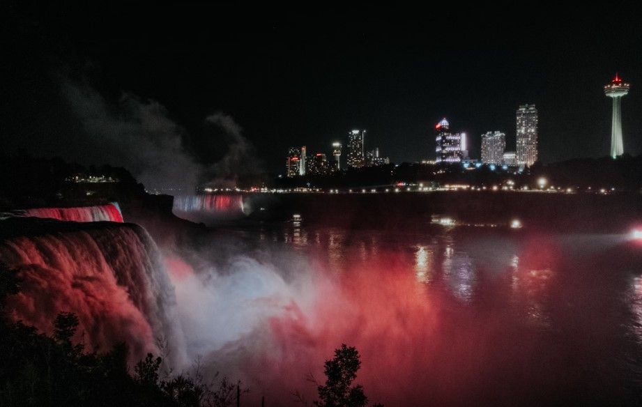 cataratas del niagara de noche, iluminadas, ciudad con edificios detrás