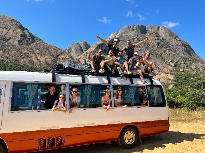 viajeros de weroad subidos en un autocar con detrás montaá en madagascar