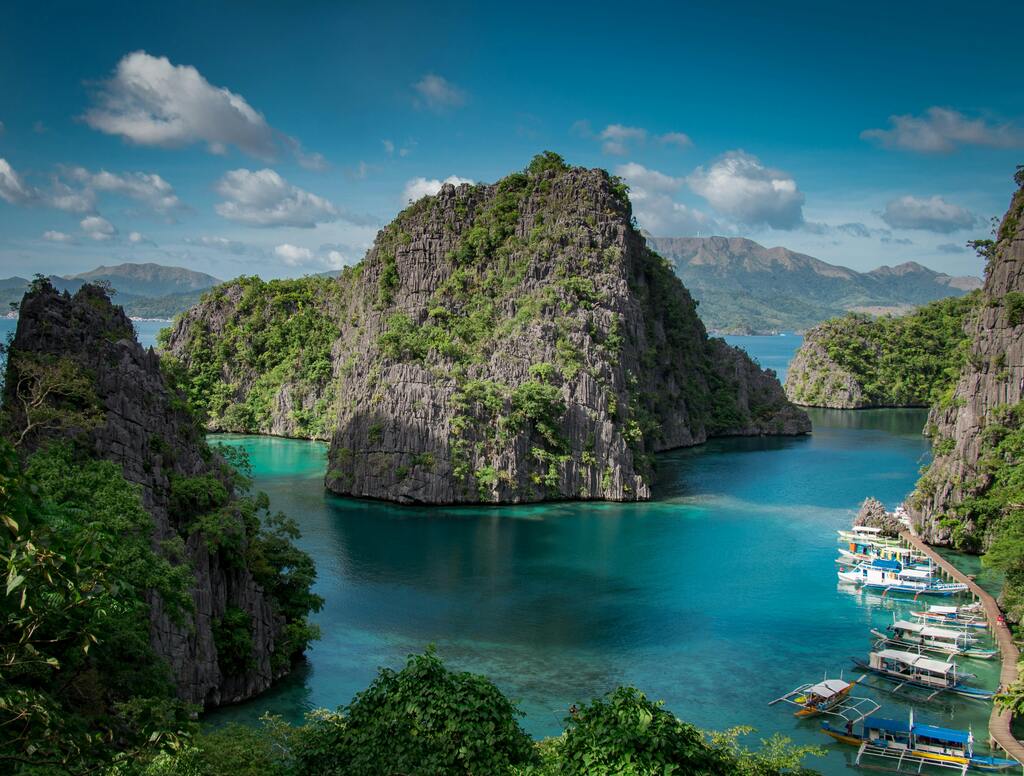 Vista panorámica de la bahía de Coron, Filipinas, con acantilados de piedra caliza y aguas cristalinas.
