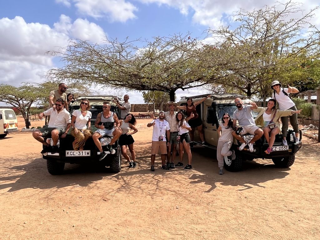 Grupo de viajeros WeRoad en un safari en África con coches 4x4