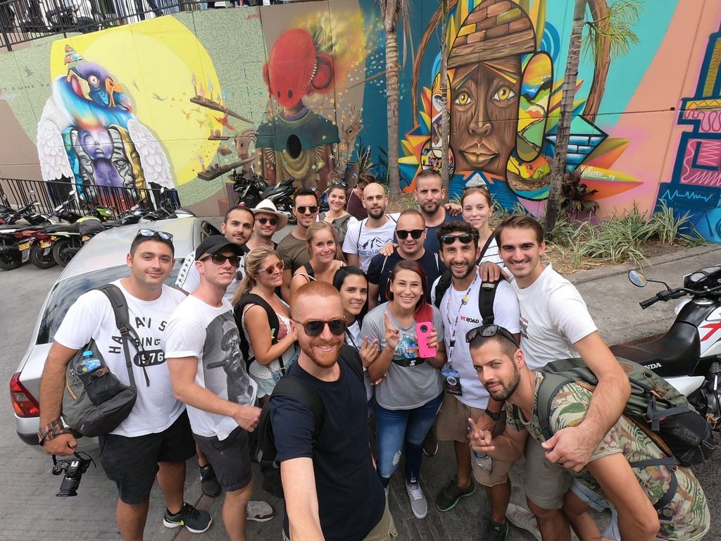 Grupo WeRoad explorando las calles de Medellín, Colombia, con murales de arte urbano
