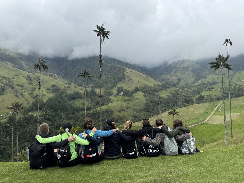 Grupo de viajeros WeRoad abrazados en el Valle de Cocora, Colombia
