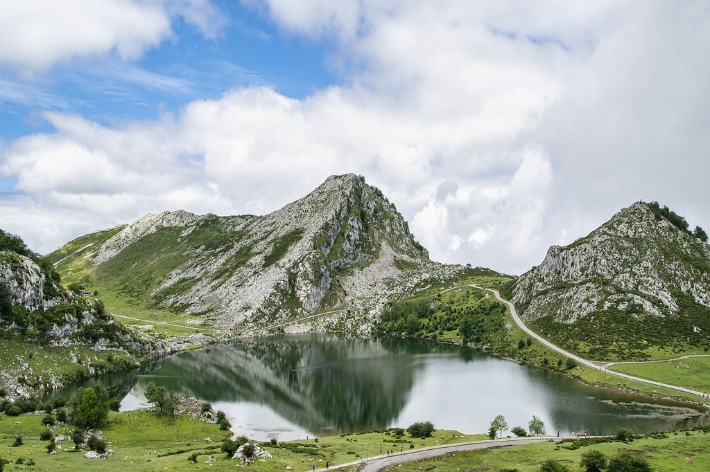 Lago Enol en los Picos de Europa, Asturias – Reflejos en el agua cristalina rodeada de montañas verdes en un paisaje natural impresionante.