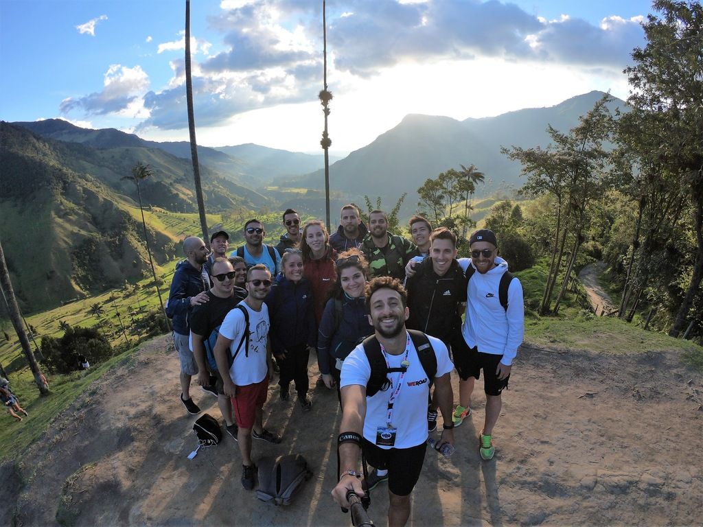 Grupo de viajeros WeRoad en el Valle de Cocora, Colombia, al atardecer
