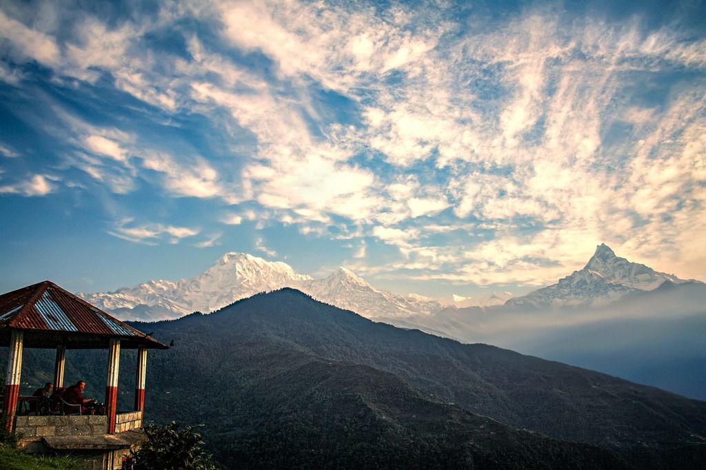 Mirador con vistas impresionantes de las montañas del Himalaya en Nepal, con el cielo despejado y nubes en el horizonte.