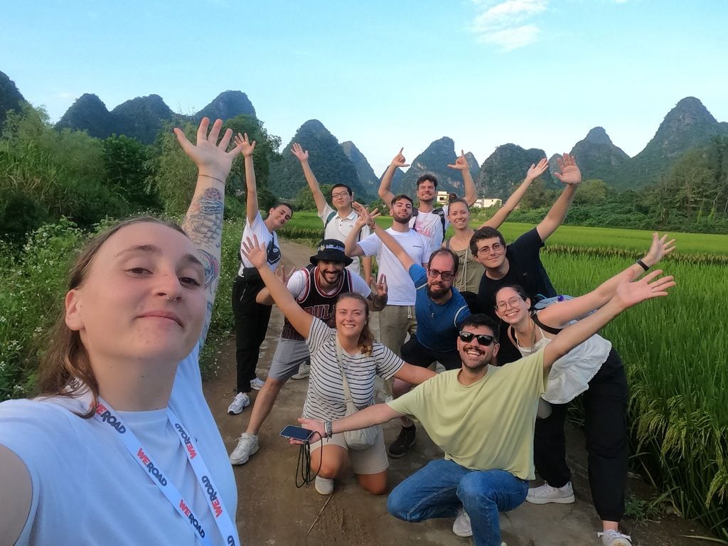 Viaje de grupo WeRoad en China, explorando paisajes de montañas kársticas y arrozales verdes.