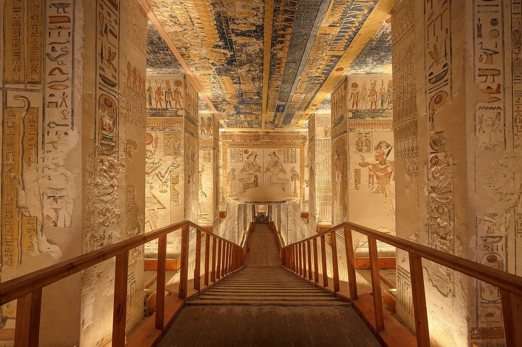 Pasillo interior de una tumba del Antiguo Egipto con murales y jeroglíficos coloridos.