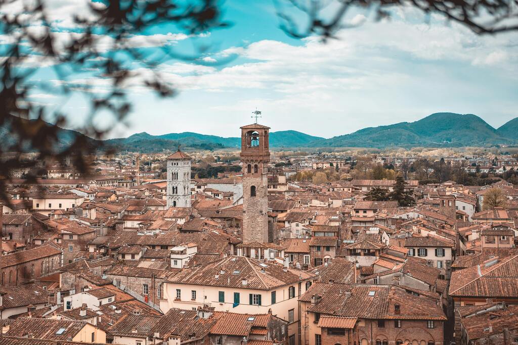 Vista panorámica de los tejados rojos de Lucca con campanarios al fondo.