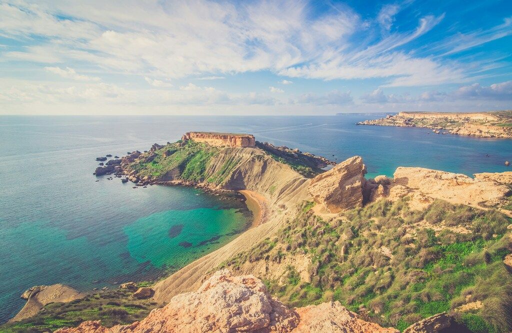 Vista panorámica de una playa de arena dorada y aguas turquesas en Malta