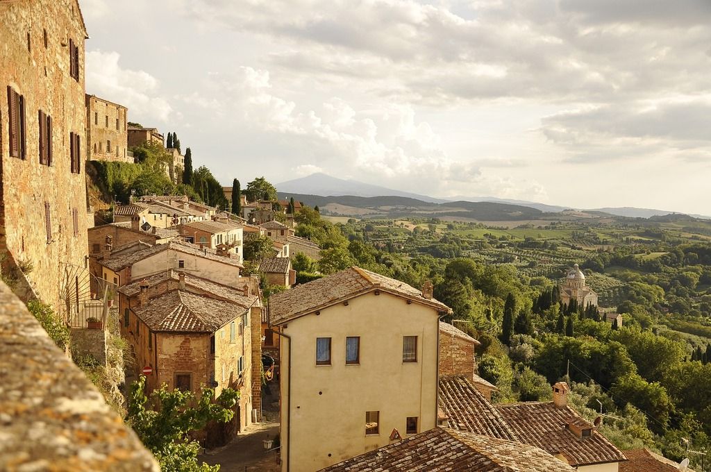Paisaje de Montepulciano con colinas verdes y casas de piedra.
