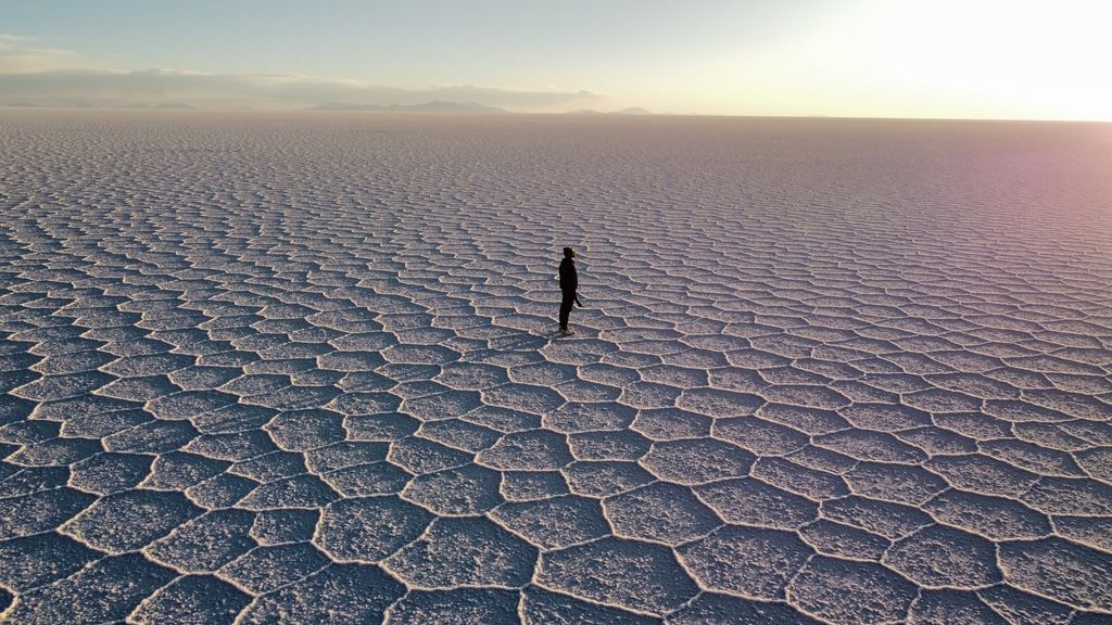Persona caminando por el Salar de Uyuni al atardecer