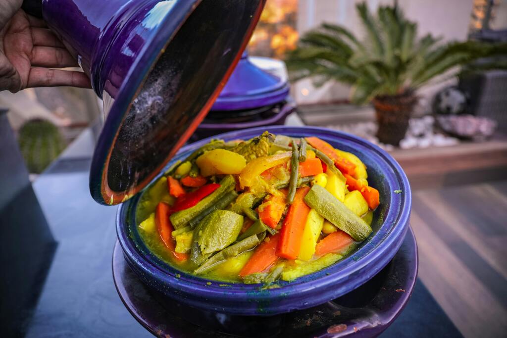 Tagine de verduras marroquí servido en una cazuela tradicional de cerámica.