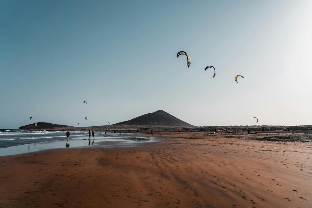 Playa de El Médano, Tenerife, con cometas de kitesurf volando sobre la arena