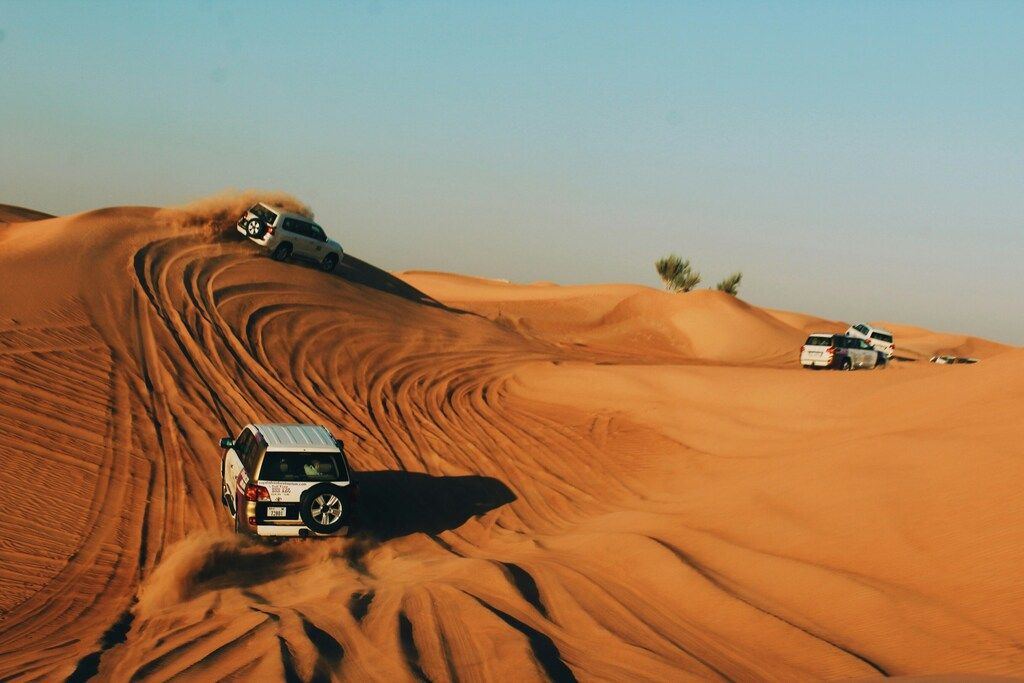 Coches todoterreno recorriendo las dunas del desierto durante una excursión de aventura.