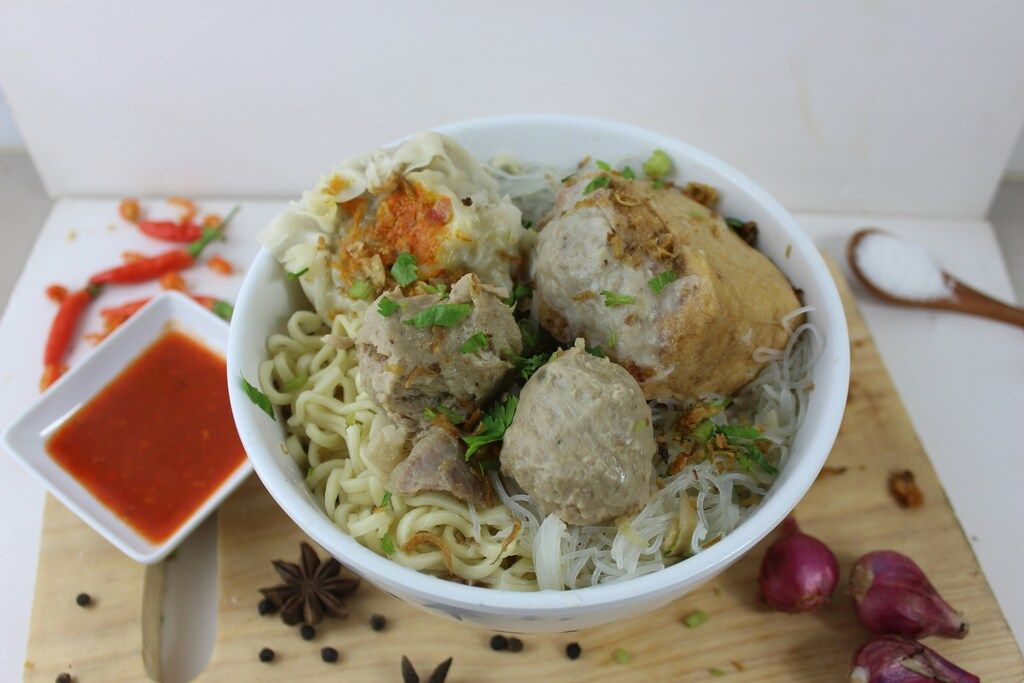 Tazón de bakso con fideos, albóndigas de carne, tofu relleno y salsa picante.