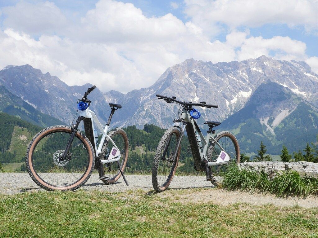Dos bicicletas eléctricas aparcadas frente a las majestuosas montañas de los Alpes.