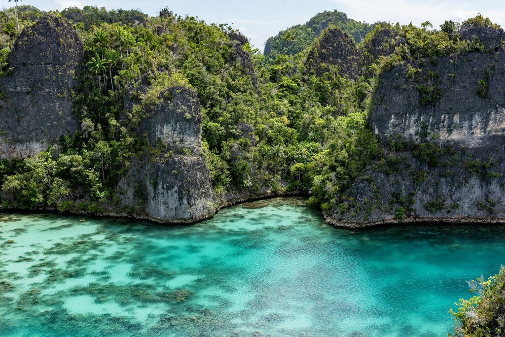 Paisaje marino de Raja Ampat, Indonesia, con islas kársticas cubiertas de vegetación y agua turquesa.