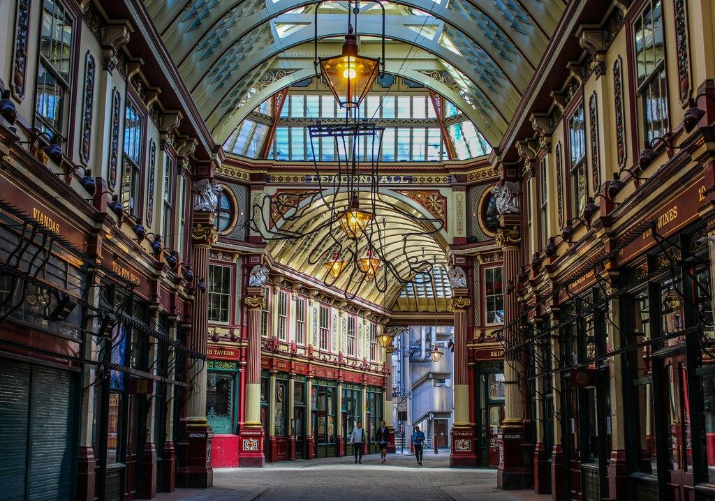 Interior de Leadenhall Market en Londres, con techos abovedados de vidrio y decoración clásica.