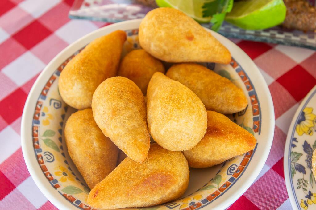 Brigadeiros de chocolate brasileños cubiertos con granas, uno de ellos con relleno visible