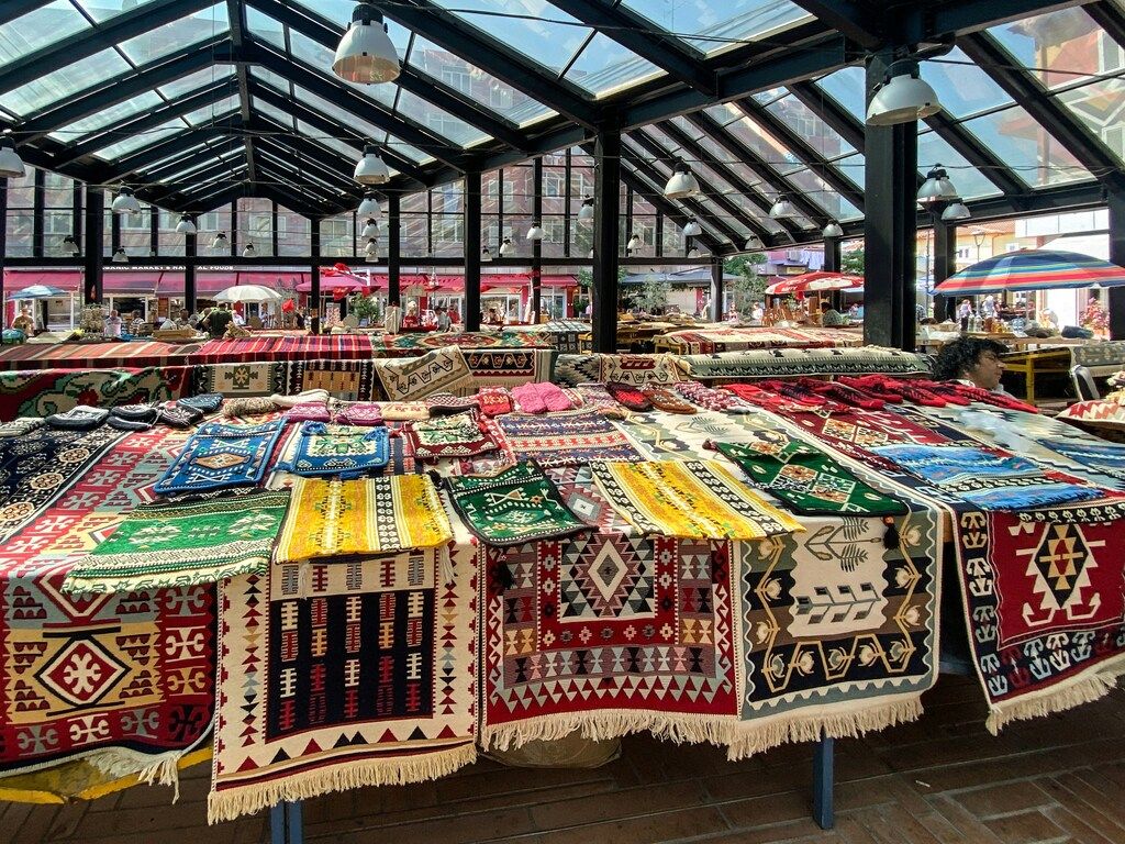 Mercado Pazari i Ri con alfombras tradicionales albanesas de colores