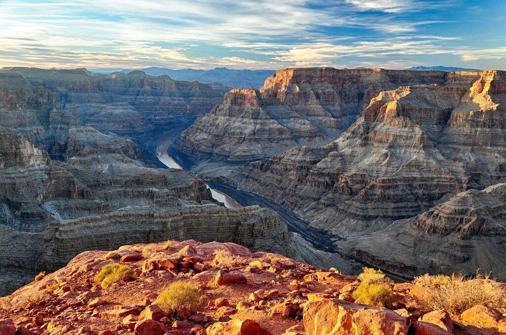 Paisaje del Gran Cañón al atardecer con luz dorada sobre las rocas.