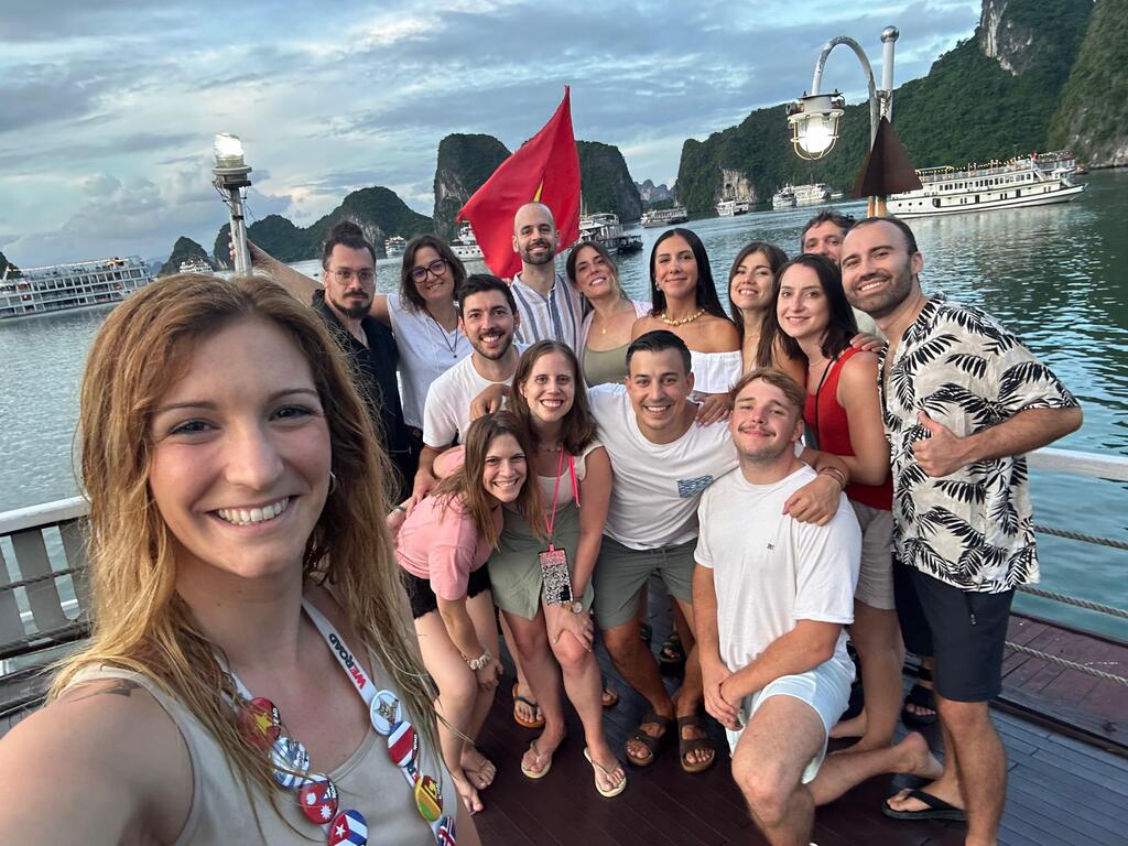 Foto de grupo de viajeros WeRoad sonriendo a bordo de un barco en la bahía de Ha Long.