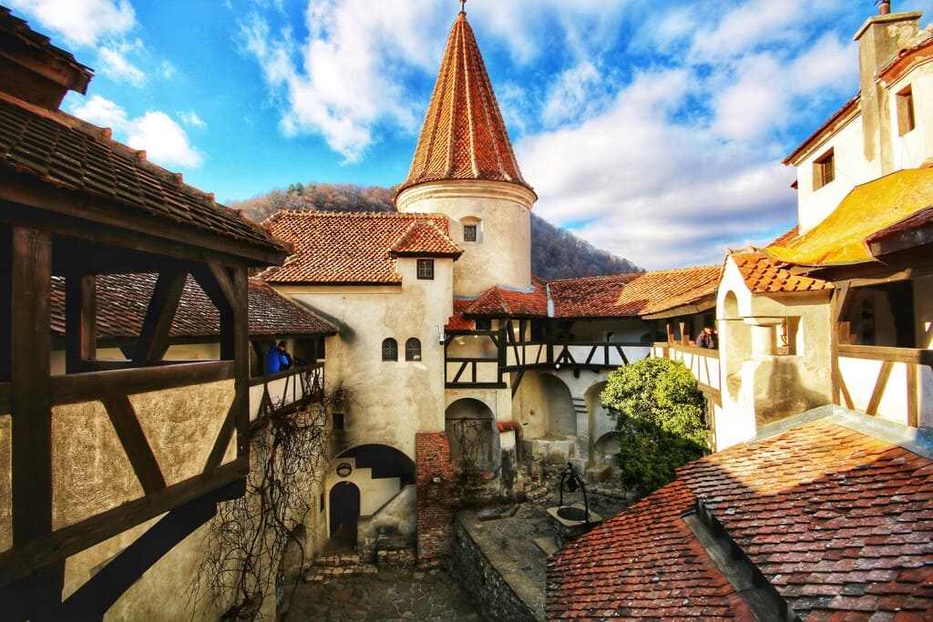 Patio interior del Castillo de Bran con cielos azules y nubes