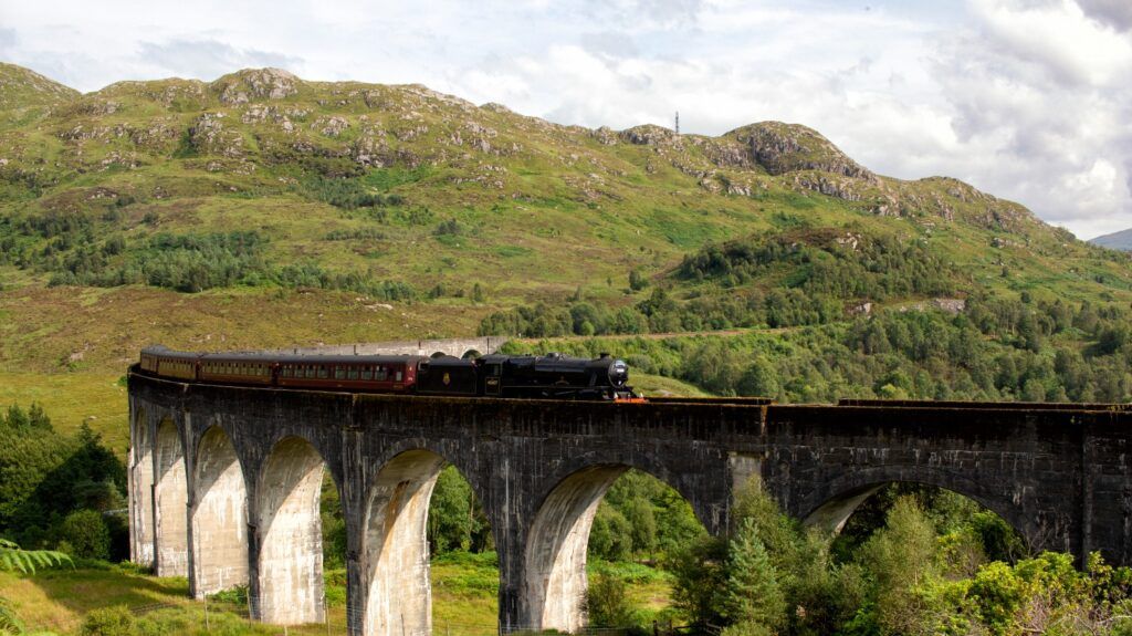 El viaducto de Glenfinnan, conocido por la saga de Harry Potter, con el tren de vapor Jacobite cruzándolo.