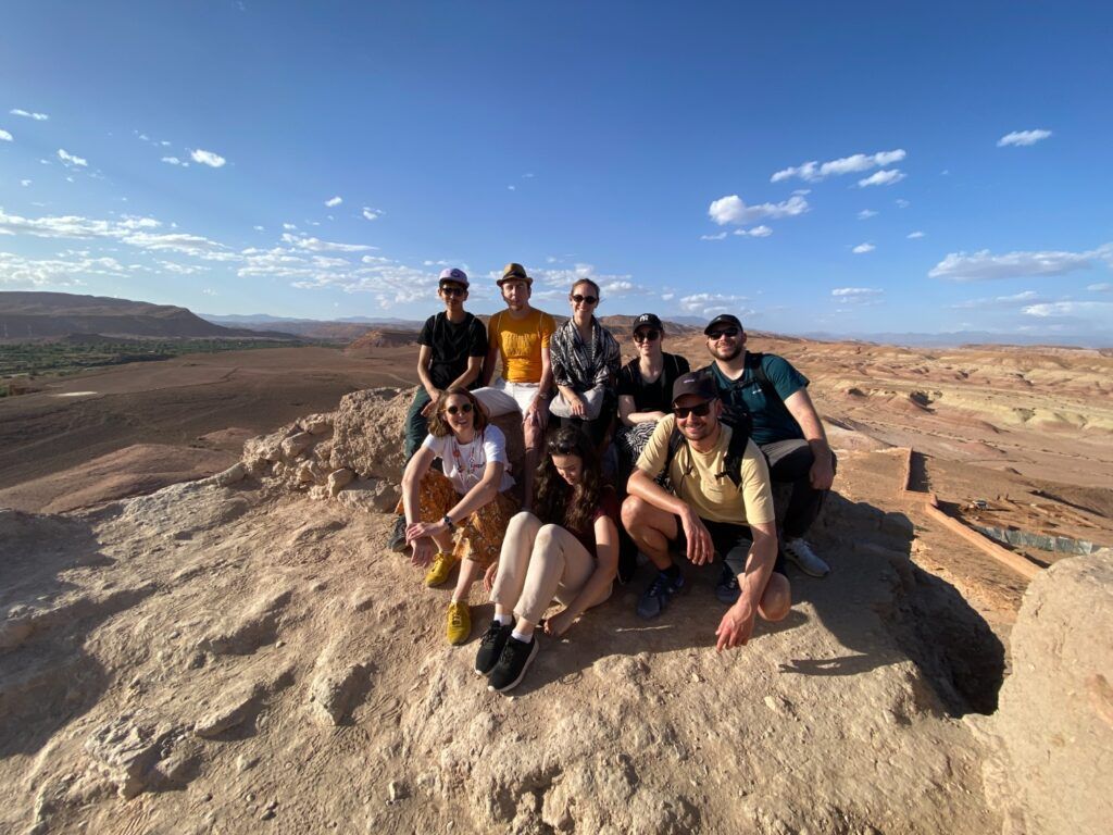 Grupo de viajeros de Weroad posando en un paisaje panorámico desértico en Marruecos.