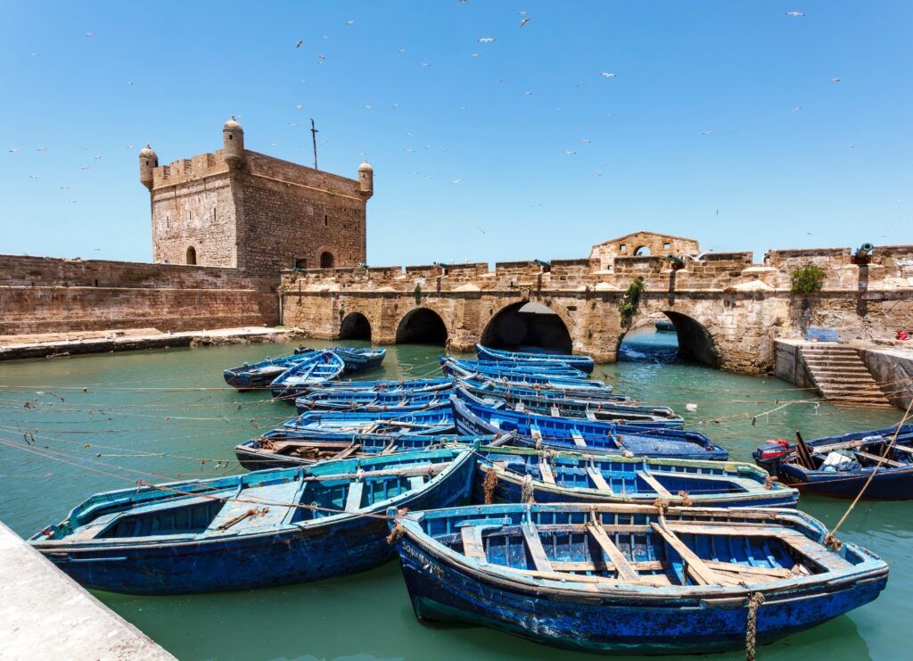 Barcas de pesca azules en el puerto de Essaouira y el Fuerte de la Isla (Borj el Barmil).
