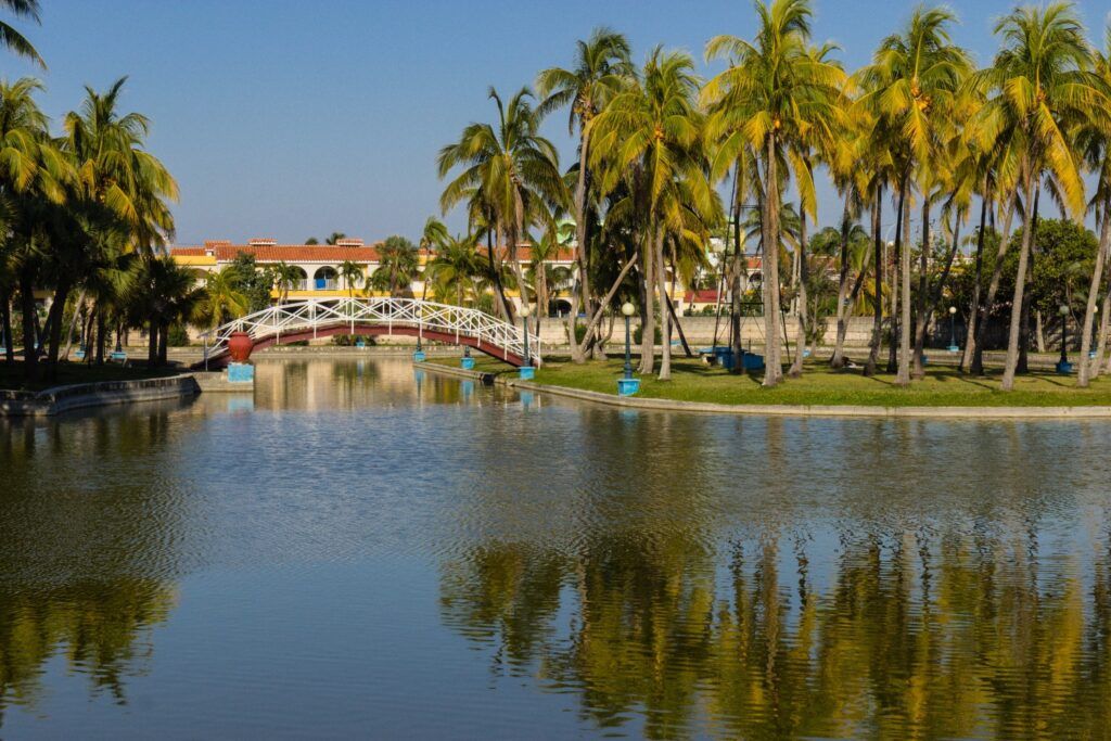Puente blanco sobre un lago rodeado de palmeras en el Parque Josone, Varadero.