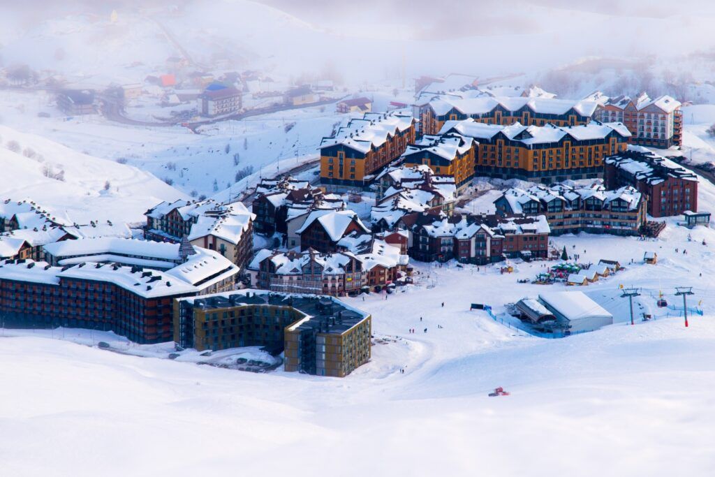 Vista aérea de la moderna estación de esquí de Gudauri, Georgia, con edificios cubiertos de nieve.