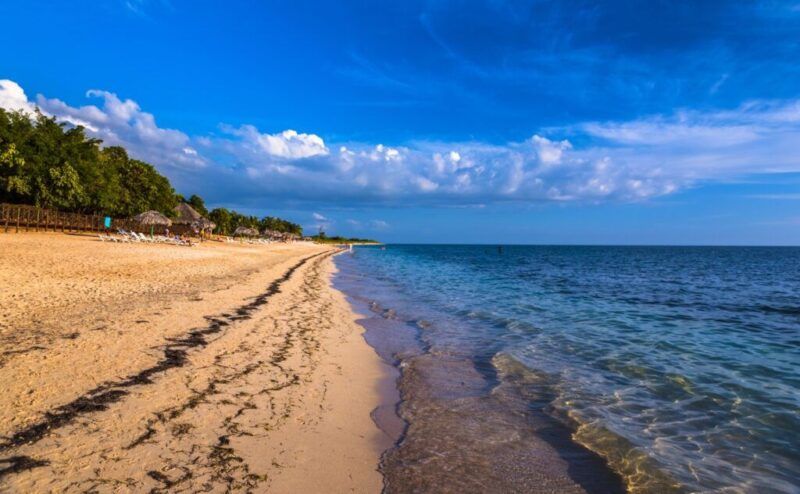 Vista al atardecer de Playa Ancón: una larga franja de arena dorada y un mar en calma.