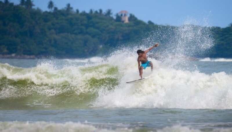Un surfista monta una gran ola espumosa en la costa de Weligama en Sri Lanka.