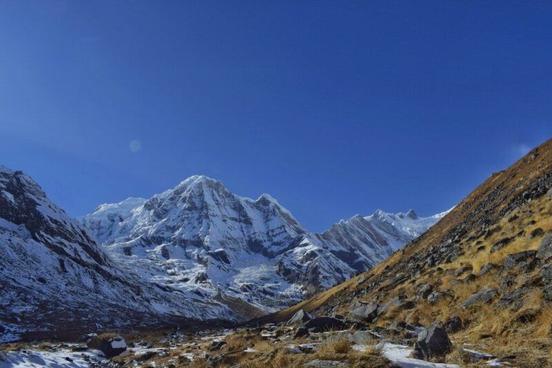 Vista despejada de las montañas nevadas de Annapurna bajo un cielo azul brillante.