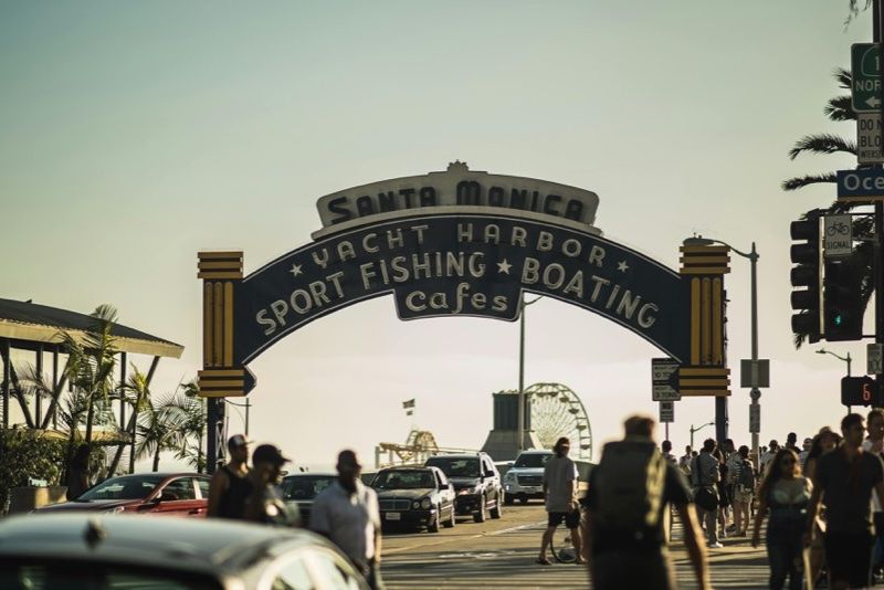 Entrada de Santa Monica con gente y coches cerca del muelle
