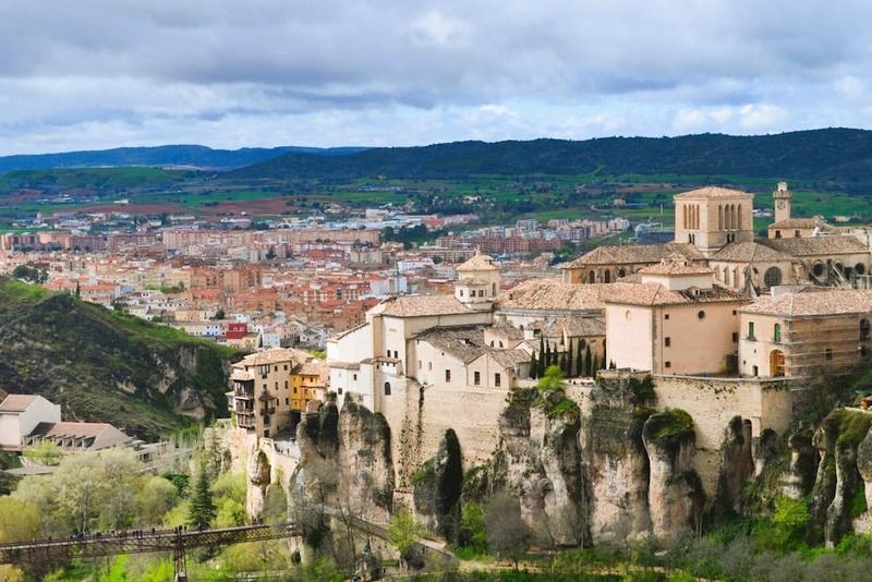 Vista panorámica de la ciudad de Cuenca con sus casas colgadas sobre acantilados rocosos y la catedral al fondo, España