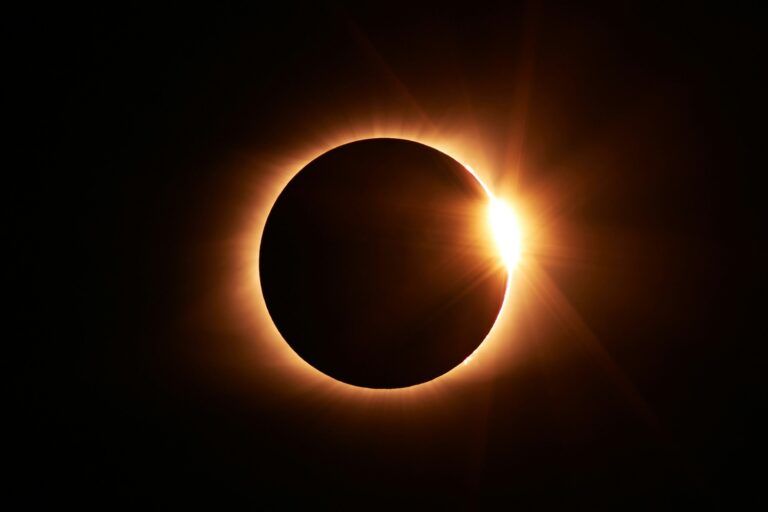 Eclipse solar total con efecto anillo de diamante, corona solar brillante alrededor de la luna en cielo oscuro