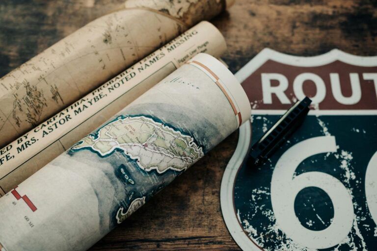 Mapas enrollados y escudo de la Ruta 66 sobre una mesa de Mapas enrollados y escudo de la Ruta 66 sobre una mesa de madera