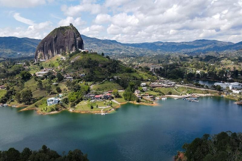 Vista aérea de la Piedra del Peñol emergiendo sobre el lago de Guatapé rodeado de colinas verdes, Colombia