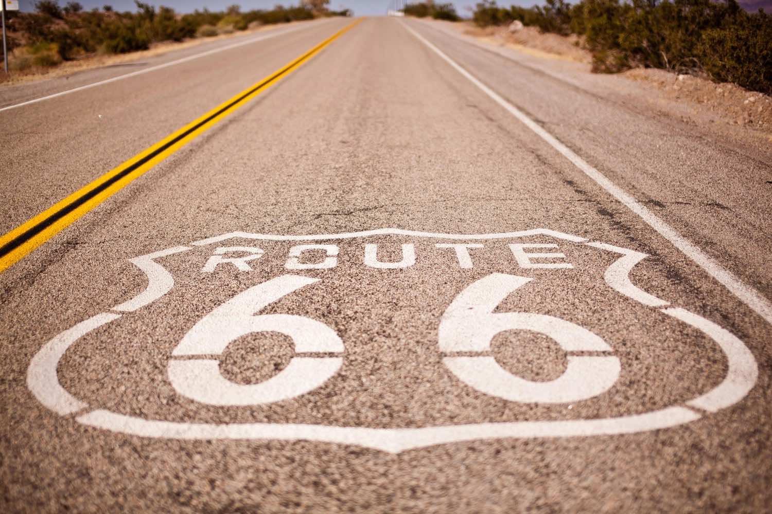 Simbolo de la Ruta 66 pintado sobre el asfalto de una carretera en el desierto