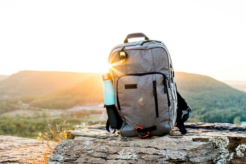 Mochila de senderismo sobre una roca al amanecer