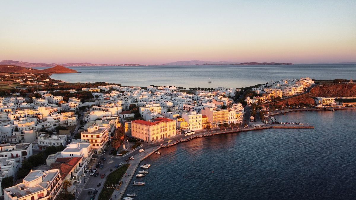 Vista aérea de la costa de Tinos al atardecer con casas blancas junto al mar