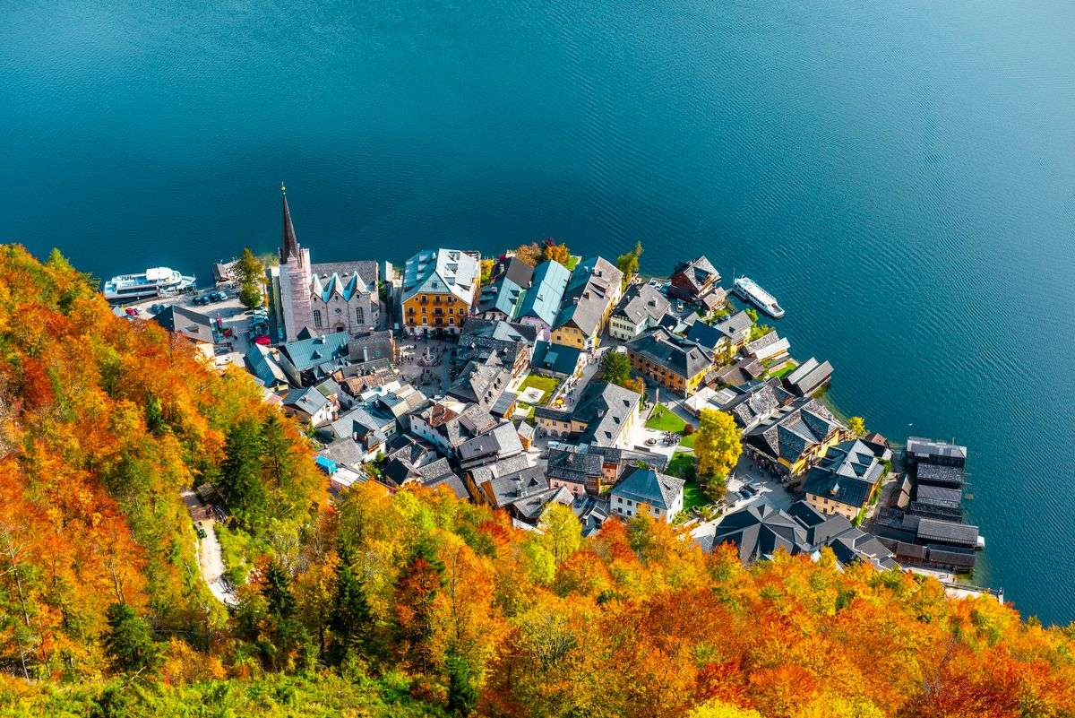 Vista aérea de Hallstatt junto al lago, rodeado de laderas con árboles de tonos otoñales