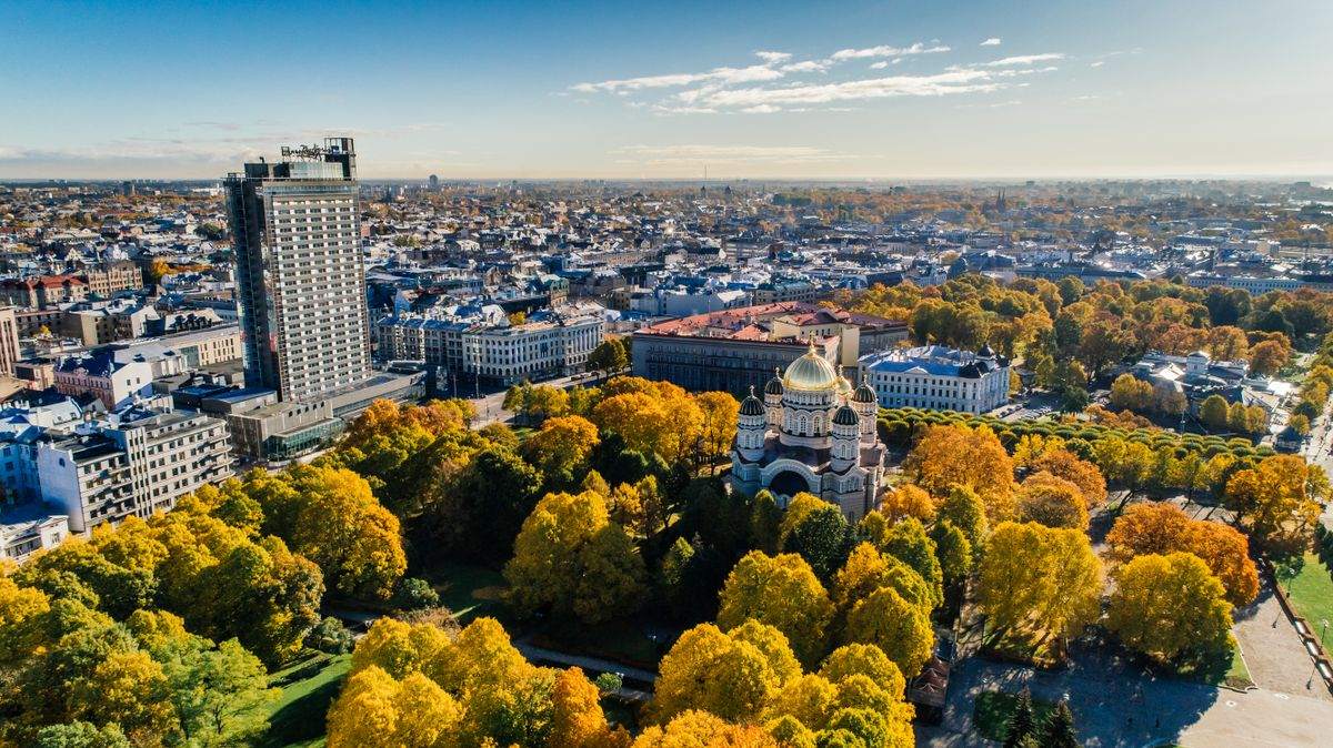 Vista aérea de Riga con catedral, parque de árboles amarillos y edificios urbanos