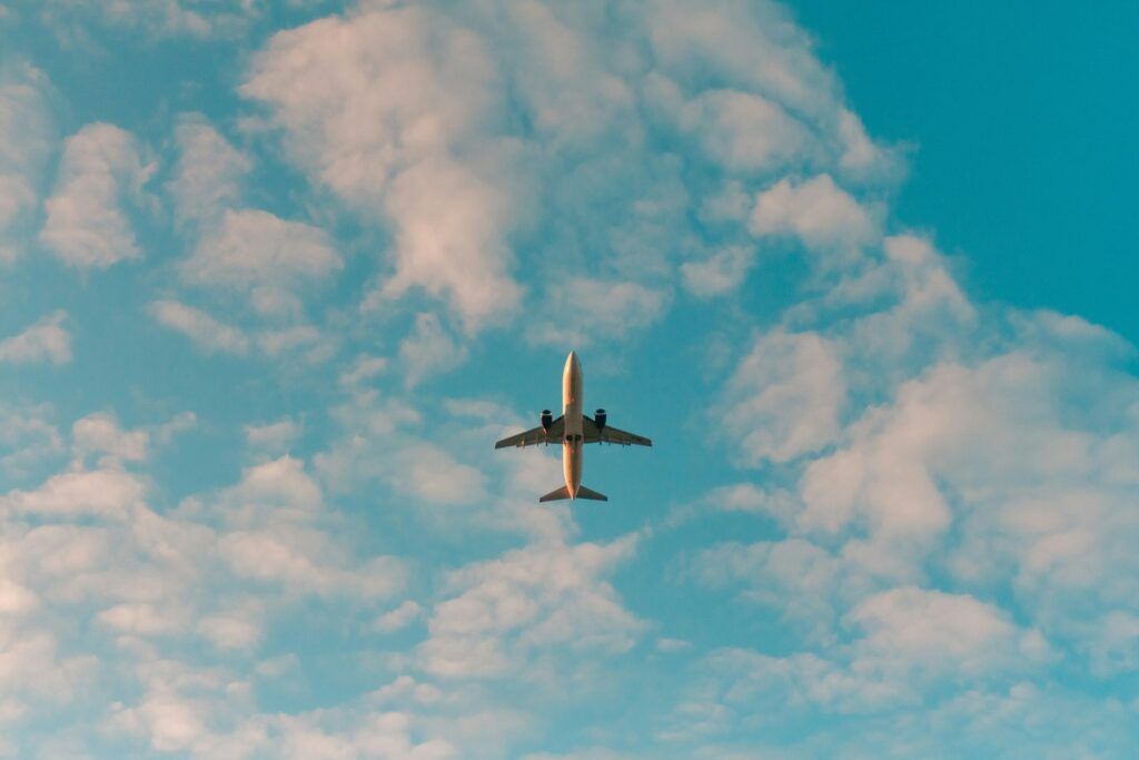 Avión volando en el cielo azul entre nubes