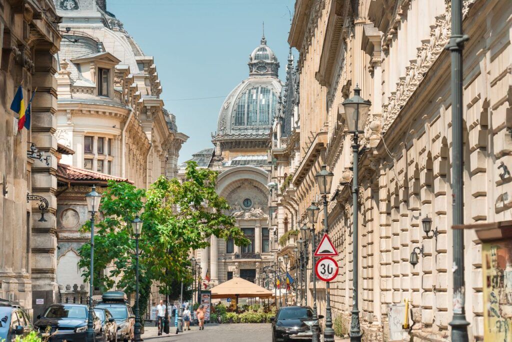 Calle del centro histórico de Bucarest con edificios señoriales y la cúpula del Palacio CEC